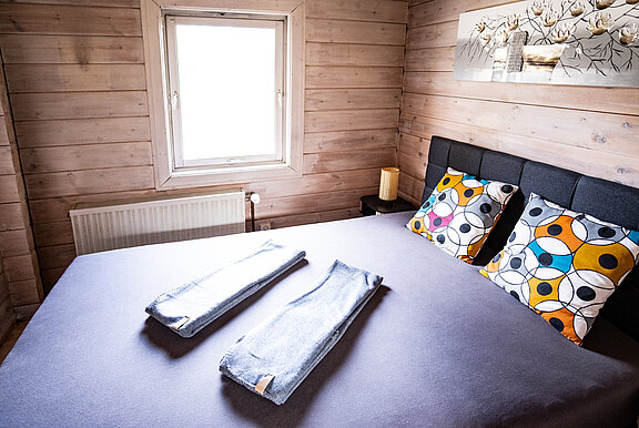 Schlafzimmer mit gemütlichem Doppelbett im Ferienhaus 'Zweite Heimat', modern eingerichtet.